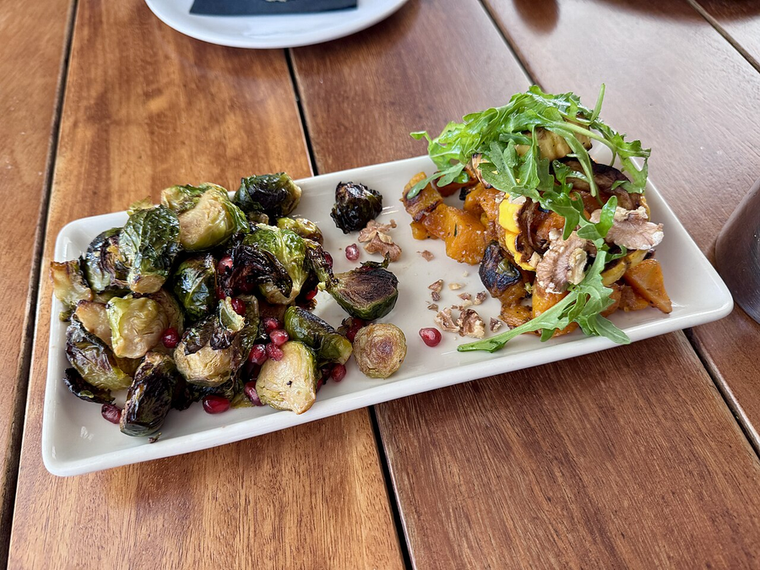 Balsamic Brussels Sprouts — charred sprouts with balsamic and pomegranate on a white plate