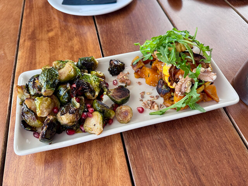 Balsamic Brussels Sprouts — charred sprouts with balsamic and pomegranate on a white plate