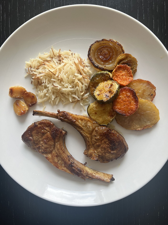 Jerk lamb chops with rice and roasted vegetables on a white plate