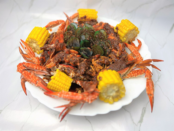 The Pescatarian Rx — seafood boil with crab, shrimp and corn on a white plate