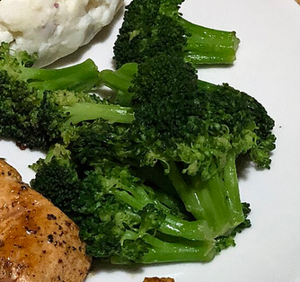 Roasted broccoli florets on a white plate