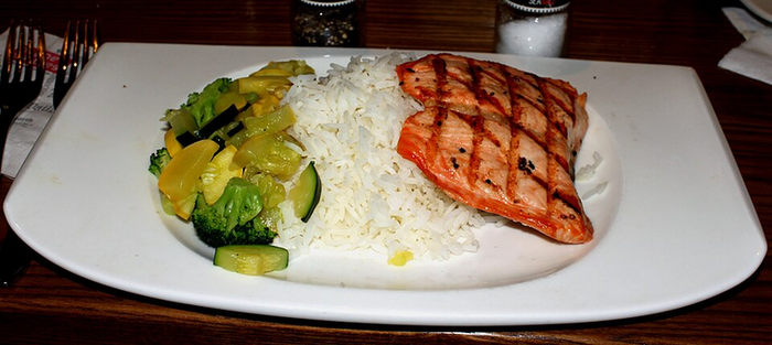 The Medi Rx — grilled salmon with rice and sauteed vegetables on a white plate